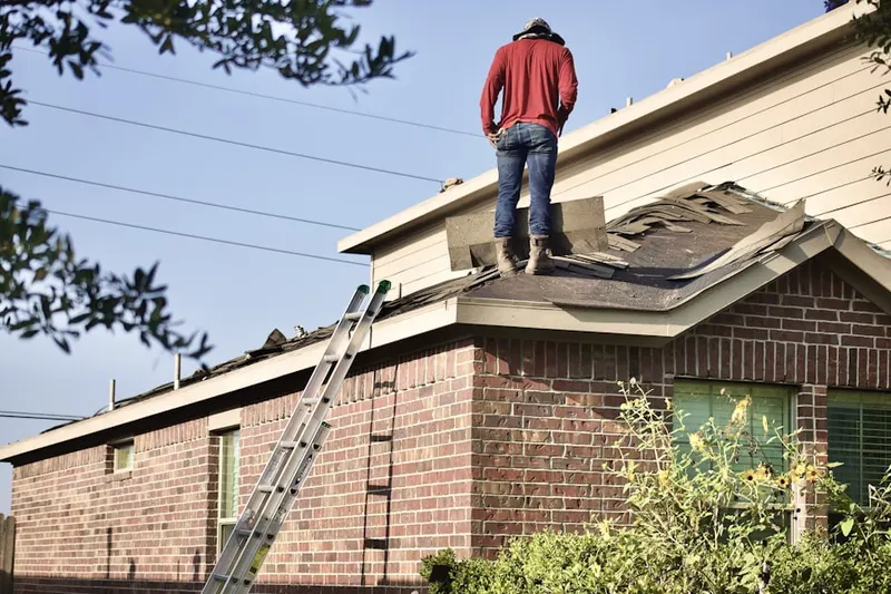 Professional roofer working on a residential roof in Eliot